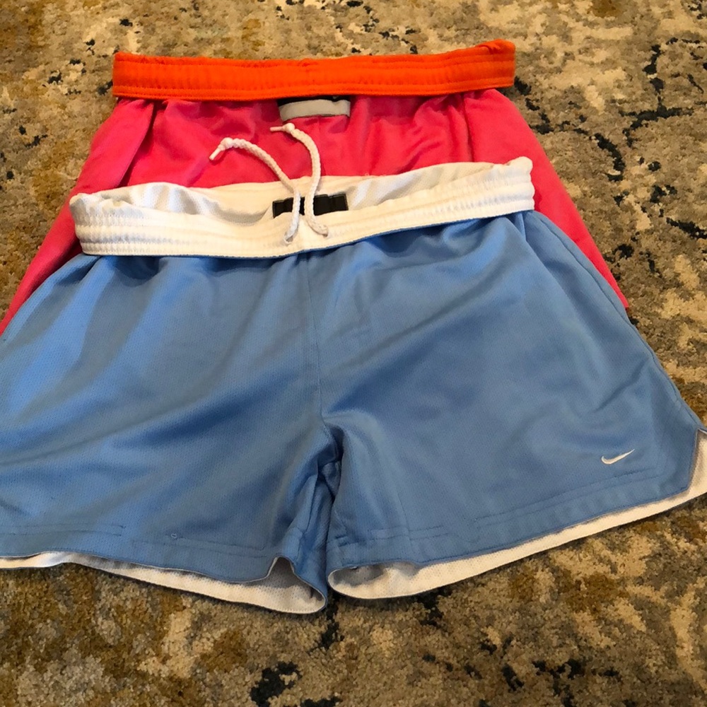 2 pairs Nike activewear shorts - 1 blue white pair, 1 orange pink neon pair